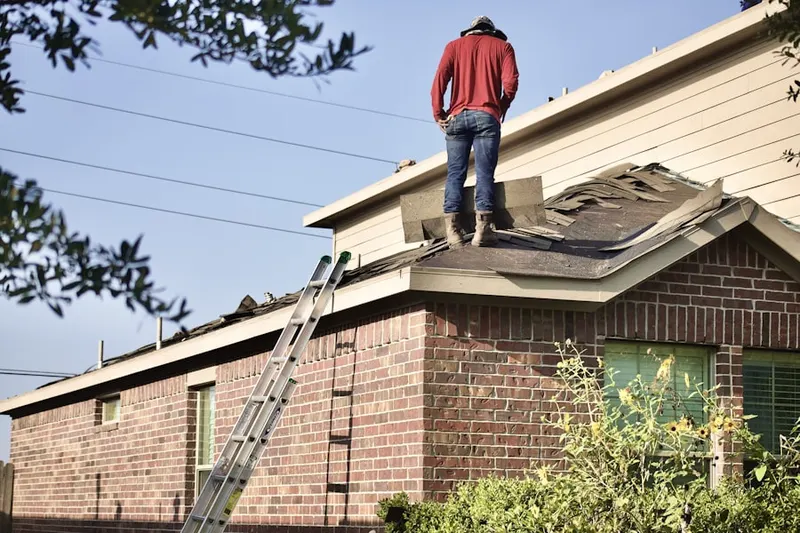 Professional roofer working on a residential roof in Reeder